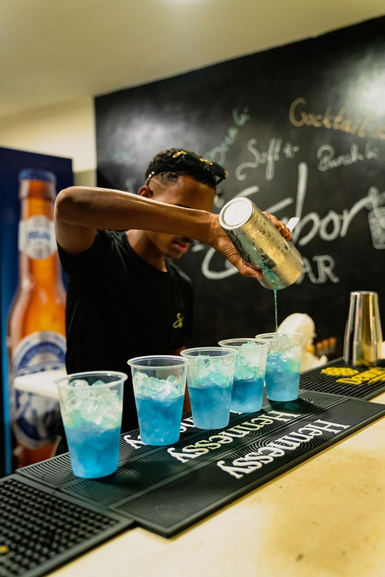 Een barman schenkt een blauwe vloeistof in.'