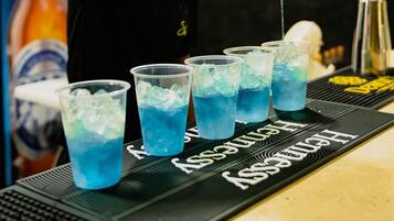 Een barman schenkt een blauwe vloeistof in.'