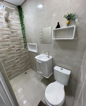 A modern bathroom with a toilet, sink, and shower. - Apartment in Copacabana Inhangá. In the best location in Rio de Janeiro, Copacabana. (Rio de Janeiro)