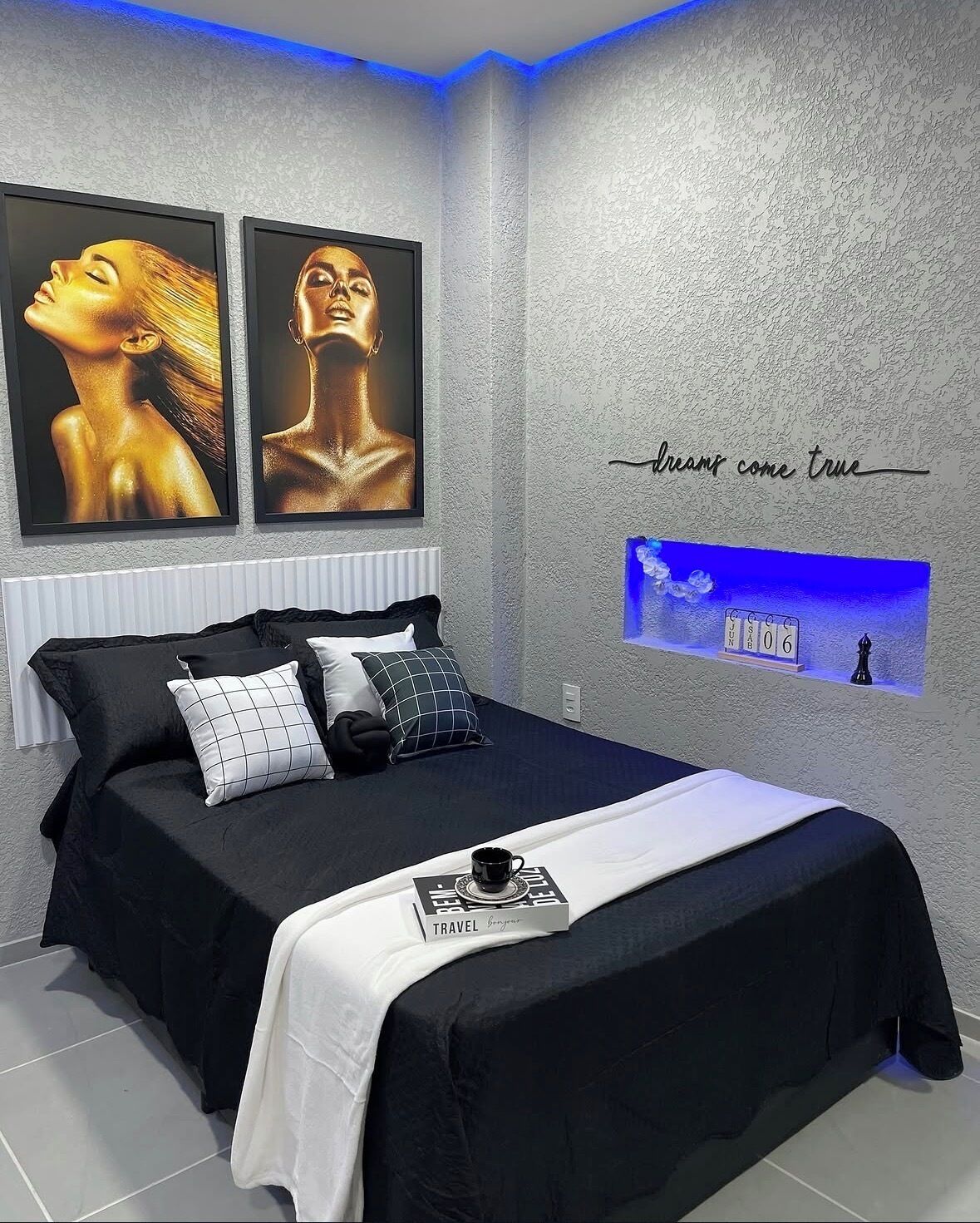 Ein modernes Schlafzimmer mit Bett, Kissen, einem gerahmten Kunstwerk, einer Wanduhr und einem motivierenden Zitat.