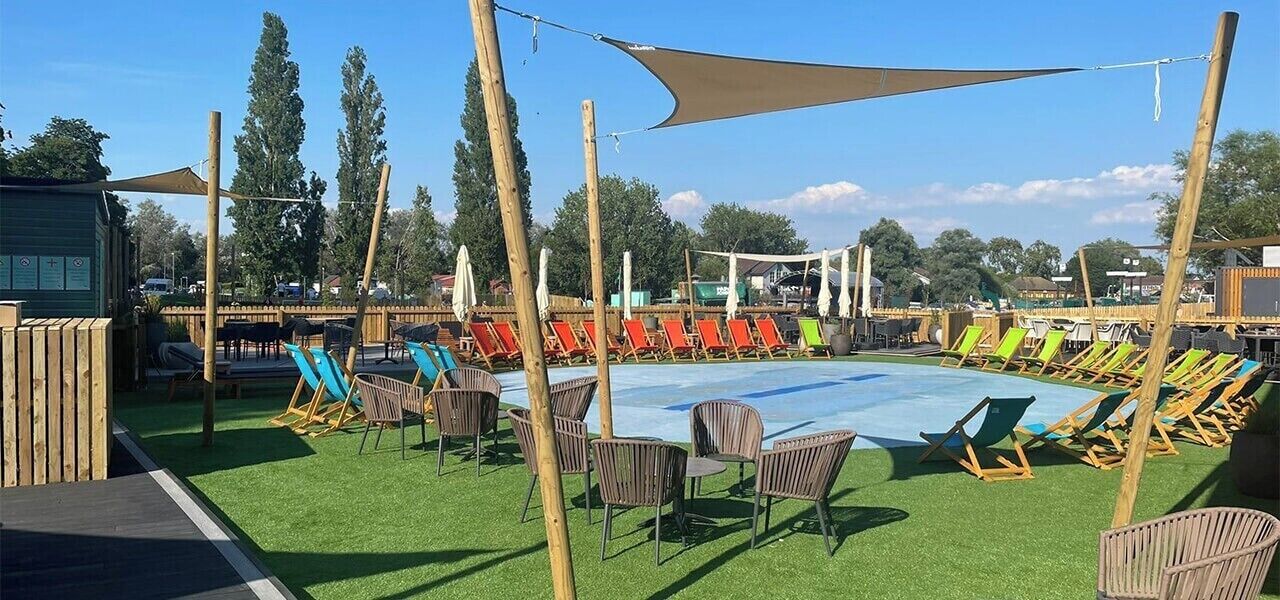 An outdoor swimming pool area with lounge chairs and a shaded area.
