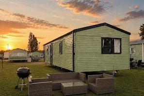 A mobile home with a patio area, outdoor furniture, and a barbecue grill. - Billing Aquadrome Holiday Park - 2 Bedroom, Silver (Northampton)