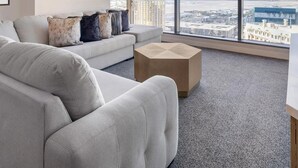 Ein modernes Wohnzimmer mit großem Fenster, einer Couch und einem Couchtisch.