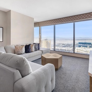 A modern living room with a large window, a sofa, and a coffee table.