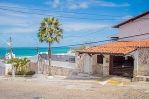 A coastal property with a stone facade, a tiled roof, and a view of the sea. - Sol Praia Ponta Negra (Natal)