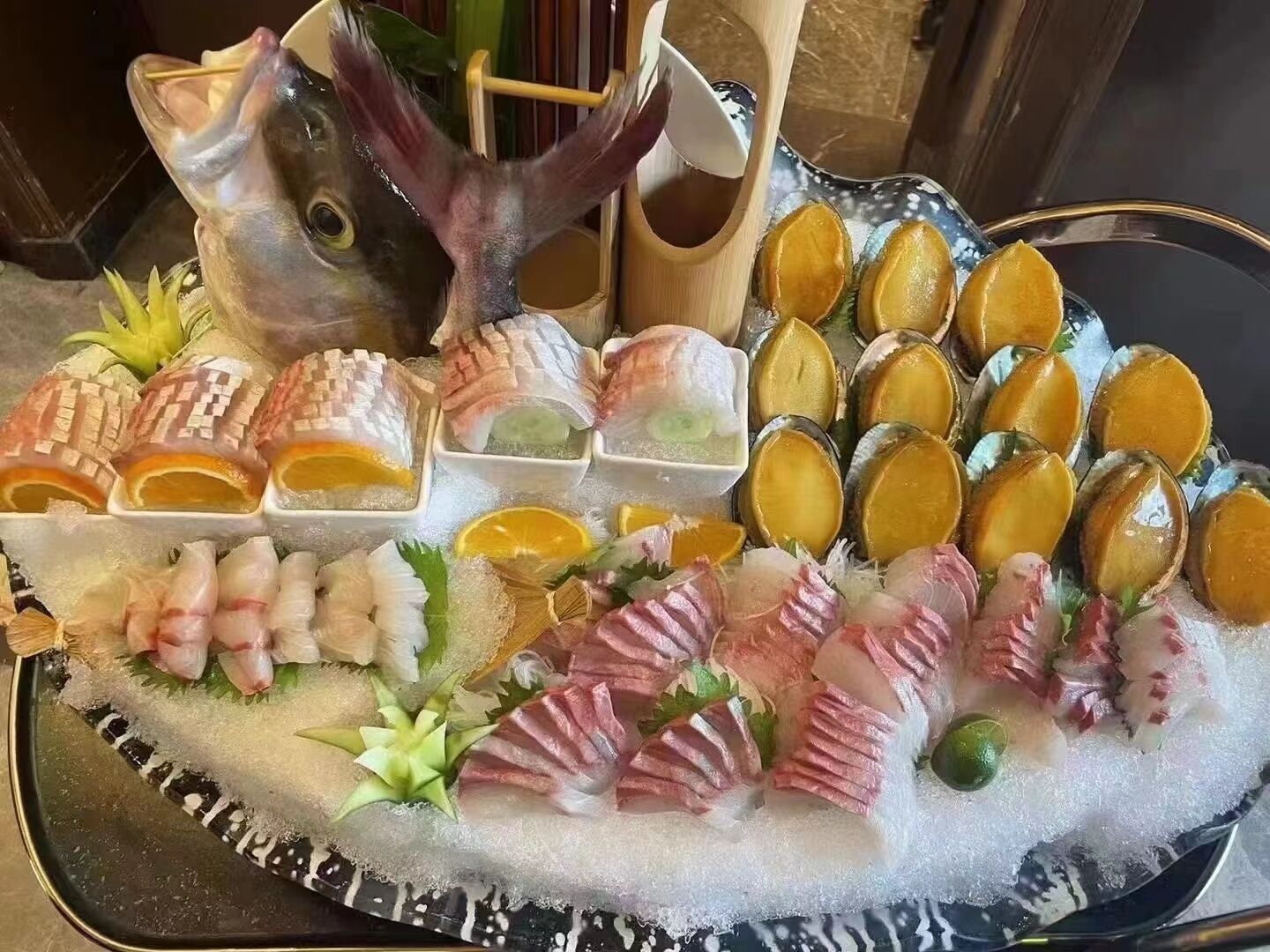A seafood platter with various types of fish and shellfish, arranged on a bed of ice.
