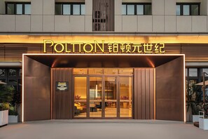 A hotel entrance with a sign reading 'POLITON' and a sign indicating 'HOTEL & DELIGHTROF' with a name 'XIAO'.