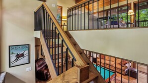 A wooden staircase leading to a second-floor area with a pool and outdoor seating. - Lakefront 4BR/3.5BA retreat with beautiful views (Oakland)