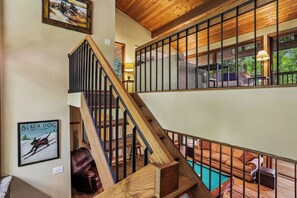 A wooden staircase leading to a second-floor area with a pool and outdoor seating. - Lakefront 4BR/3.5BA retreat with beautiful views (Oakland)