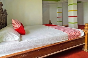 A bed with a wooden frame, white and red bedding, and a red pillow with white text. - 92326 Hotel Melati Bm Pangkep (Makassar)