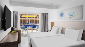 A hotel room with a bed, a desk, a television, and a view of a pool area. - Pickalbatros Vita Resort Portofino (Marsa Alam)
