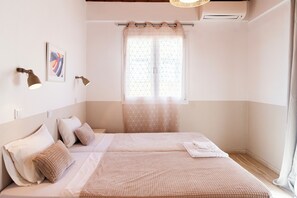 A bedroom with a bed, pillows, a window with a curtain, and wall-mounted lights. - Eleonas Bohotel & Annex Apartments (Corfu)