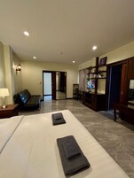 Una habitación de hotel con cama, sofá, televisor y escritorio.