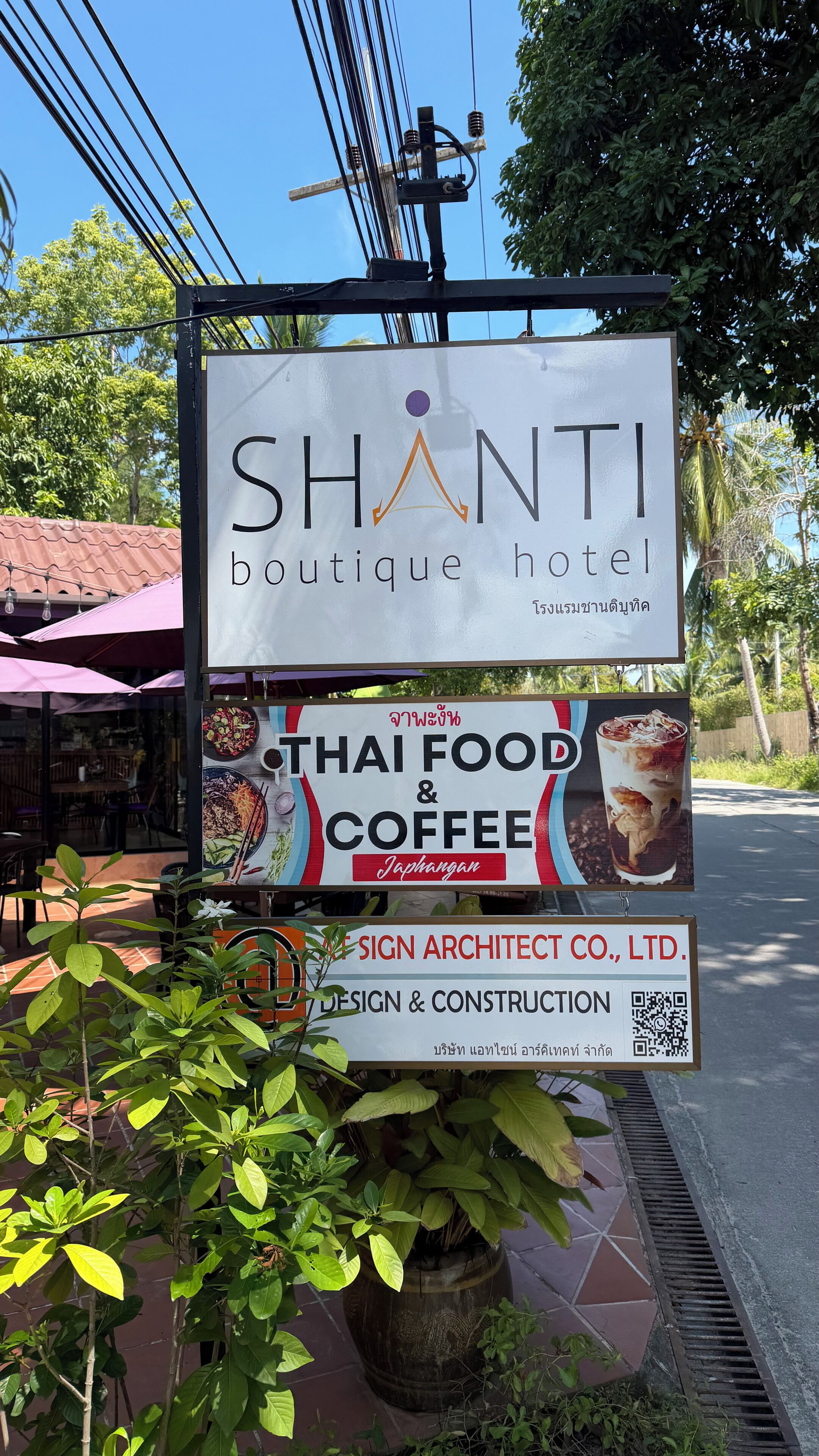 Letrero del Shanti Boutique Hotel que anuncia comida tailandesa y café.