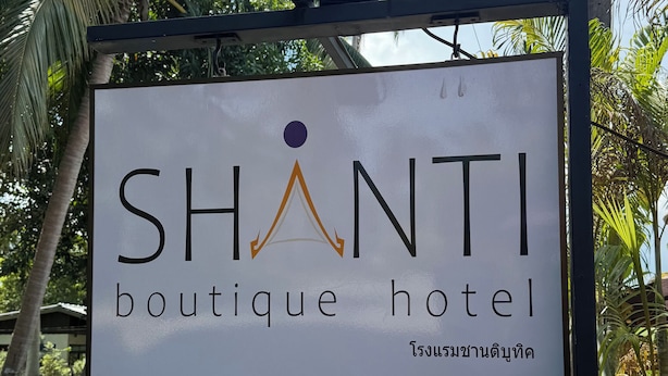 En skylt för boutiquehotellet SHANTI, som serverar thailändsk mat och kaffe, och en skylt för SIGN ARCHITECT CO., LTD.