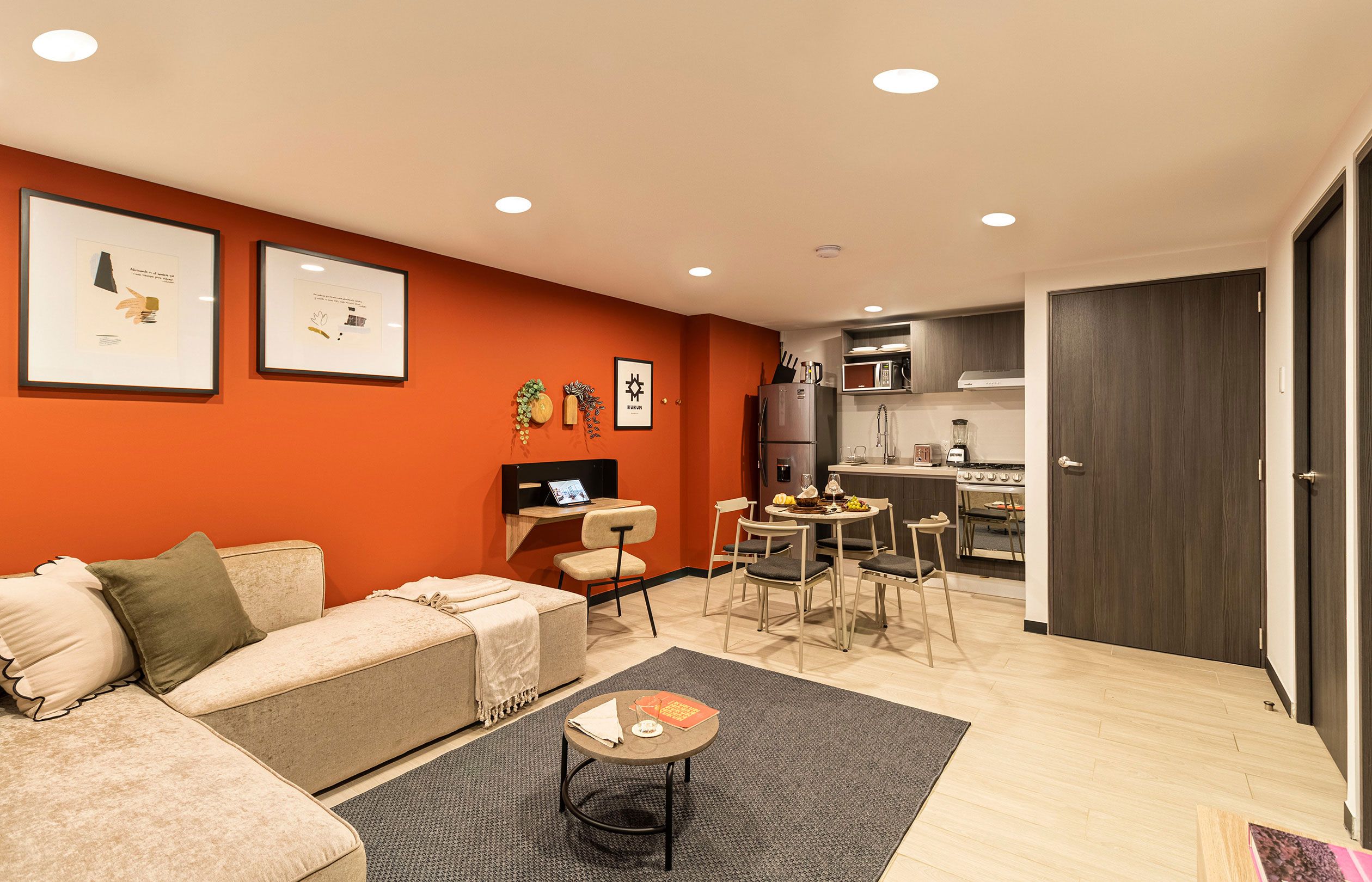 A compact living space with a sofa, a small dining table, and a kitchenette.
