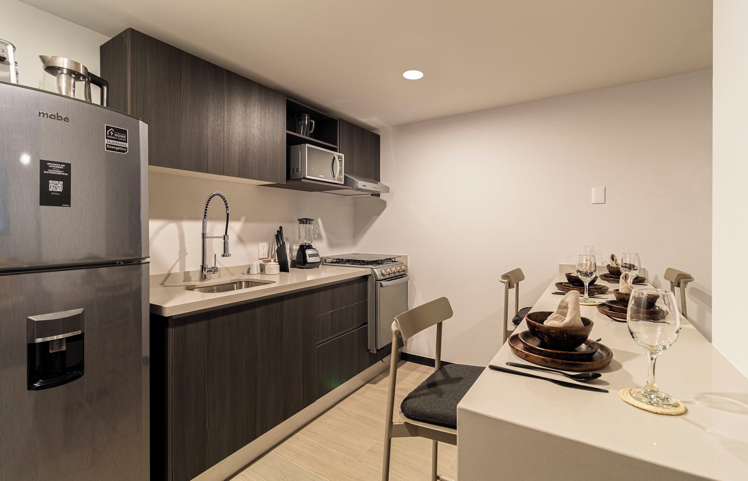 A modern kitchen with a built-in microwave, a stainless steel refrigerator, and a gas stove.