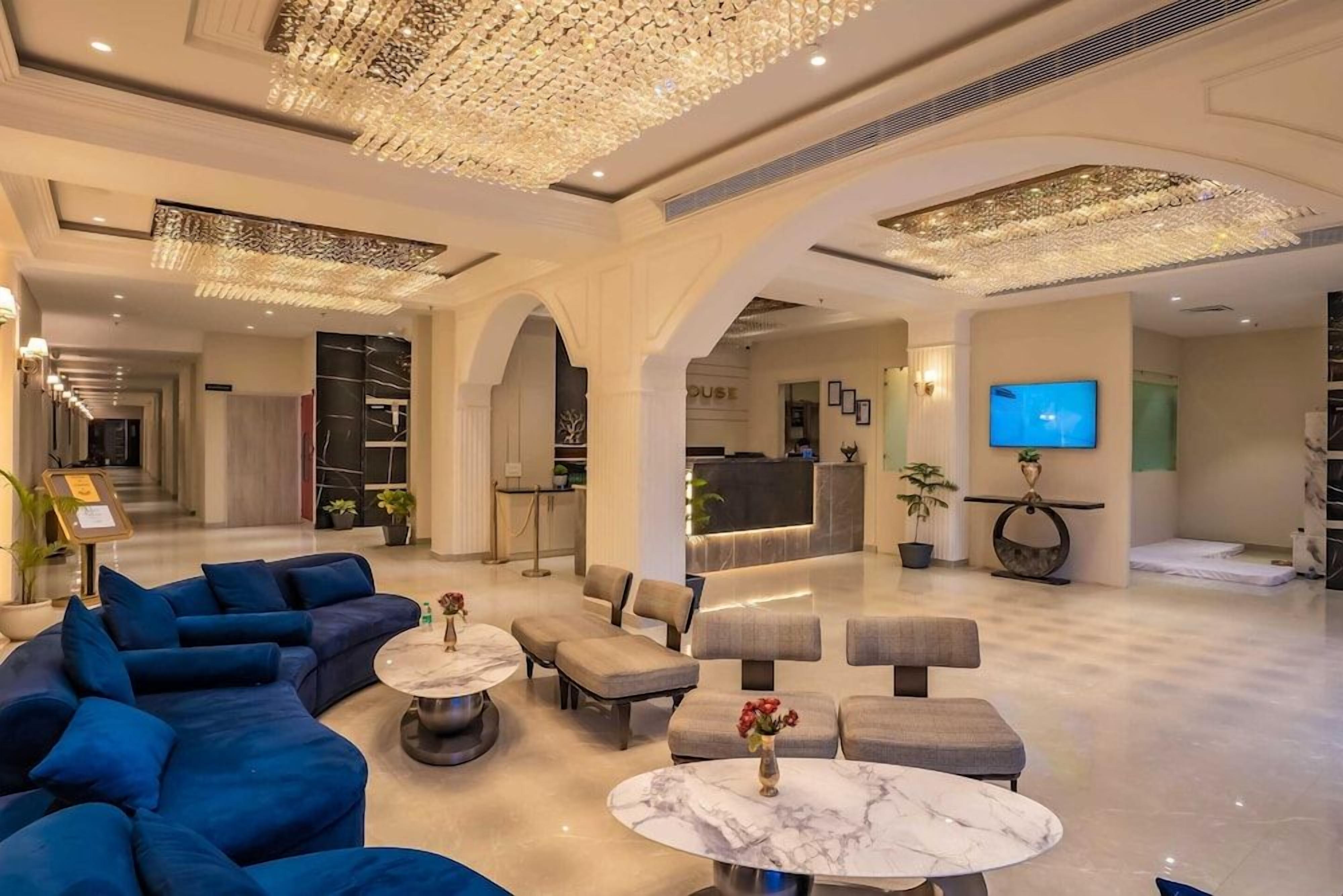 A spacious lobby with a reception desk, seating areas, and a television.