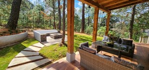 An outdoor patio with a built-in fire pit, seating area, and a pergola structure. - Cima Boreal Chalet (Tapalpa)