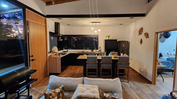 Un espace de vie compact comprenant une cuisine, un coin repas et un coin salon.