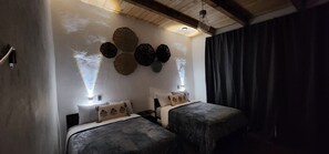 A room with two beds, a ceiling fan, and decorative wall art. - Cima Boreal Chalet (Tapalpa)