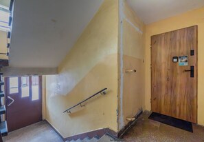 Eine Treppe mit Handlauf, die zu einer Holztür führt.
