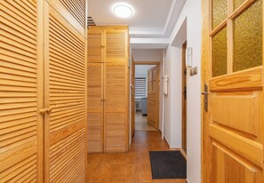 Un couloir avec des portes en bois et un radiateur.
