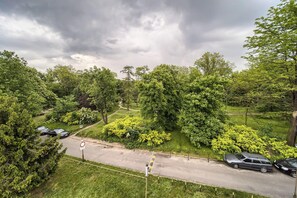 A residential area with a paved road, parked cars, and lush greenery. - Park Skowroni Homely Studio (Wrocław)