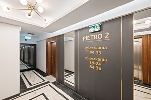 Um corredor interno com uma placa indicando 'PIETRO 2' e números de andar para diferentes áreas.