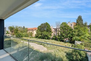 Uma varanda com vista para a paisagem urbana, incluindo edifícios e árvores.