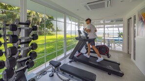 A gym with a treadmill, weight bench, and dumbbells. - Villa Carpe Diem by Elite Havens (Phang Nga)
