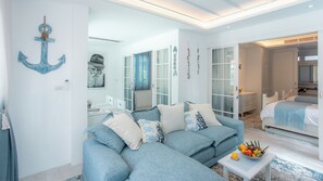 A modern, nautical-themed room with a sofa, a small table with fruit, and a bed with a headboard. - Villa Carpe Diem by Elite Havens (Phang Nga)