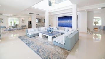 A spacious living area with a large sectional sofa, a coffee table, and a decorative wall.
