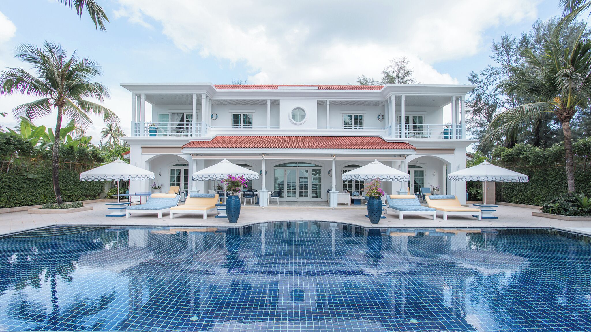 Una casa de dos pisos con una piscina delantera.