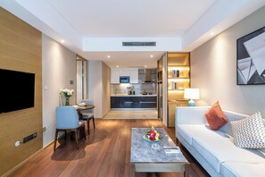Una sala moderna con un sofá, una mesa de centro y un comedor con sillas.