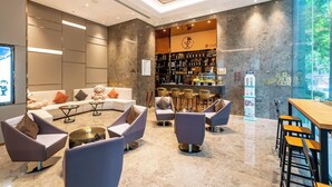 Un espace lounge moderne avec des sièges, un bar et un coin café.