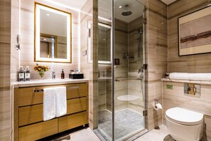 A modern bathroom with a glass-enclosed shower, a wooden vanity with a mirror, and a toilet. - Cheng Du Wifc Suites Yyc Preferred (Chengdu)