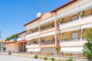 A multi-story residential building with balconies, satellite dishes, and air conditioning units. - Dionysos Hotel (Kassandra)