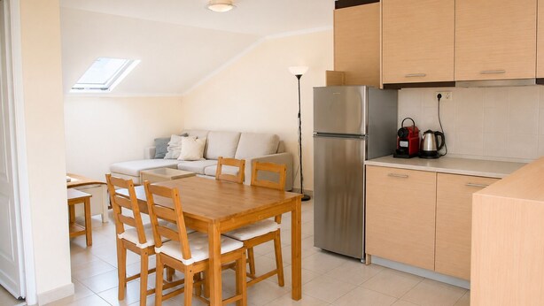 A modern kitchen with a dining area, a built-in oven, and a coffee maker. - Dionysos Hotel (Kassandra)