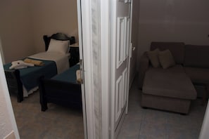 Una habitación de hotel con una cama, un sofá y una puerta.