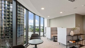 A modern office space with a large window, a round table, and a sofa. - Gorgeous Wide View 2BR High Level /Sunset/Casino (Brisbane)