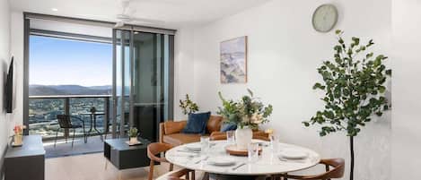 Un espace repas moderne avec une table ronde, des chaises et une vue dégagée grâce à de grandes fenêtres.