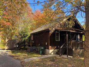 A rustic wooden building with a porch, a staircase, and a mailbox. - Pine Cove - Hot Tub - Pet Friendly - Large Yard (Campton)