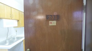 A wooden door with a 'DOOR' sign and a 'No Smoking' sign.