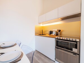 Een moderne keuken met een ingebouwde oven, een koffiezetapparaat en een broodrooster op het aanrecht.