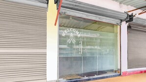Un escaparate con una persiana baja y un cartel de bienvenida en la ventana.