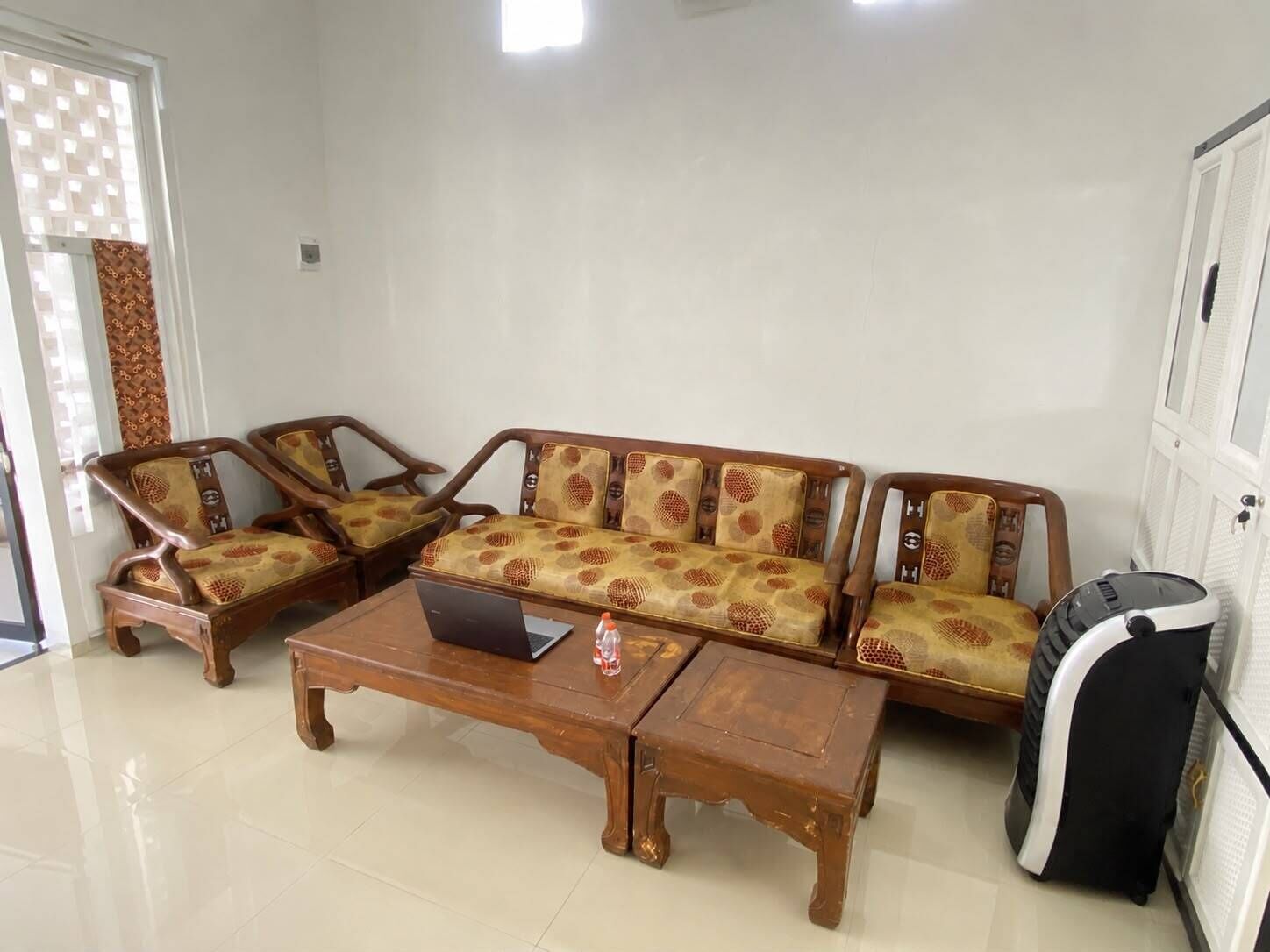 A living room with a sofa set, a coffee table, and a microwave.
