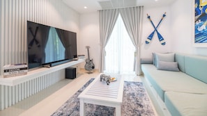 A modern living room with a flat-screen TV, a guitar, and a sofa. - Villa Carpe Diem by Elite Havens (Natai)