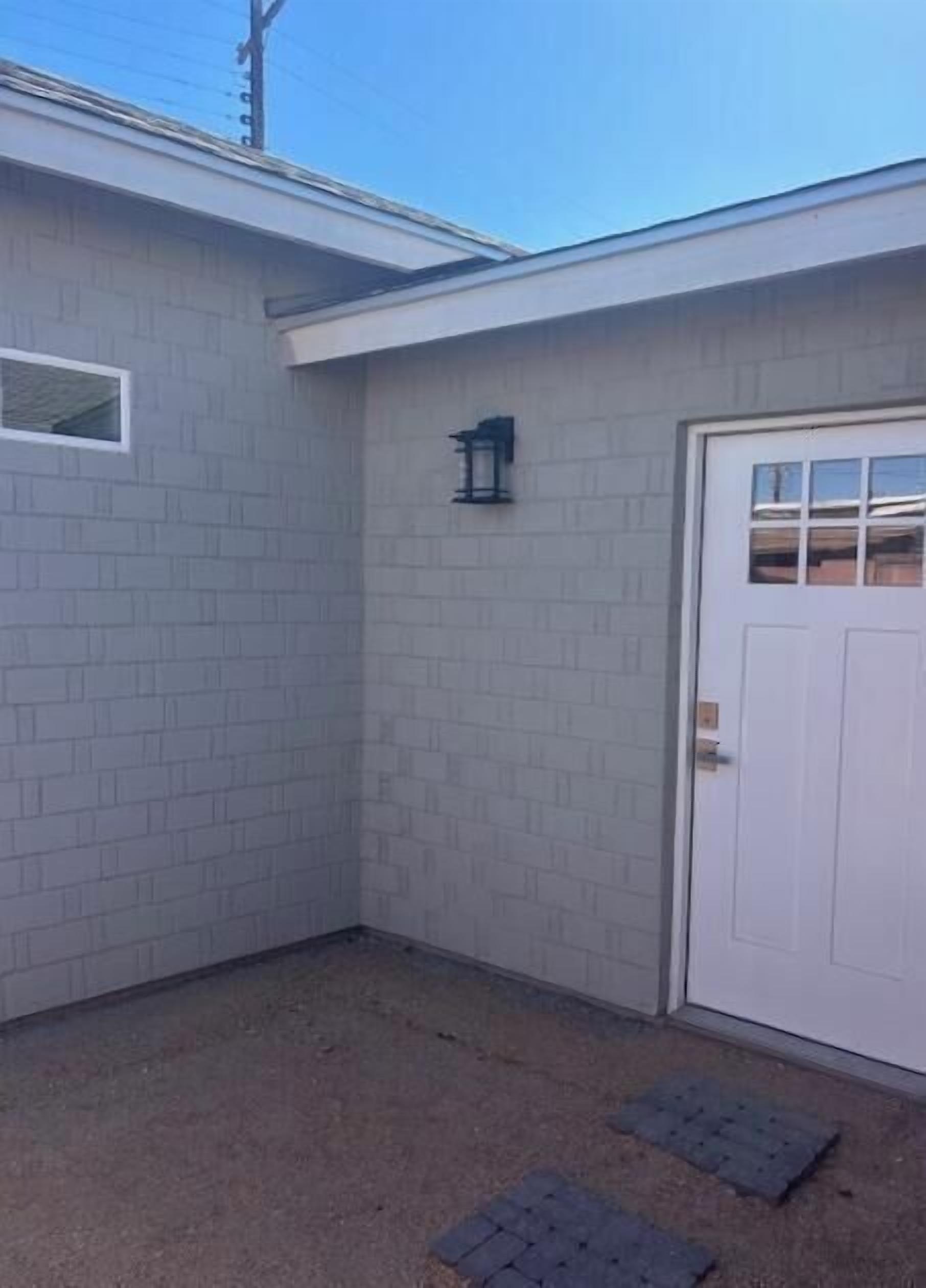 A small, enclosed garage with a white door and a small window.