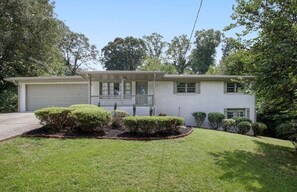 A single-story house with a garage, a front porch, and a well-maintained lawn. - Emerald Retreat - Modern 3 Bedroom Near Atlanta (Austell)